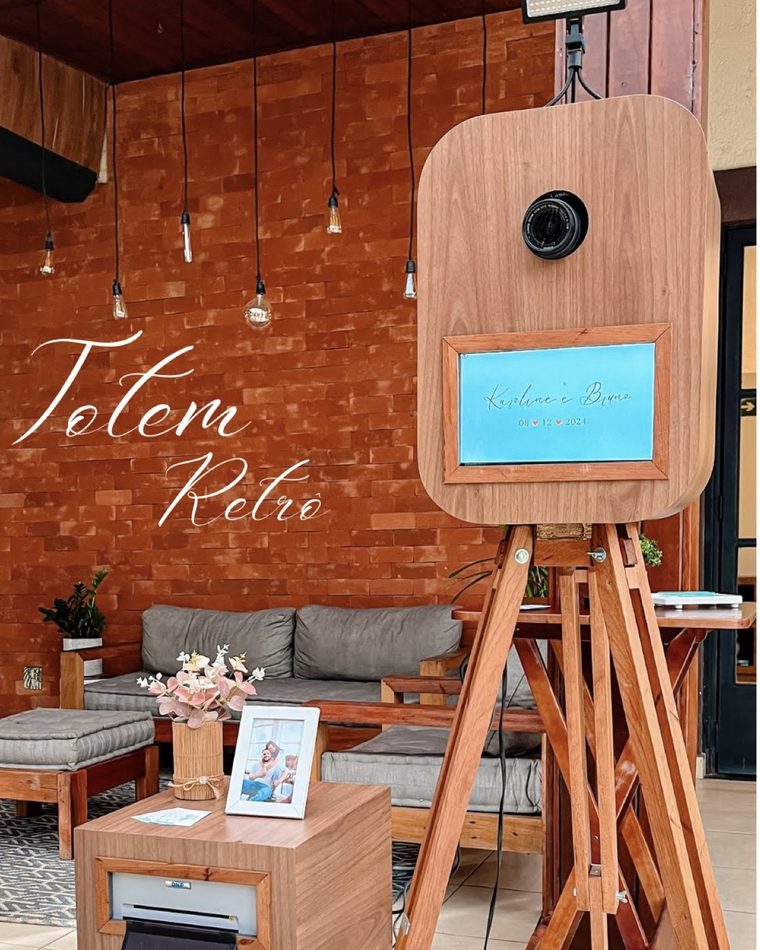 Totem Retrô em madeira sobre tripé, com tela personalizada e impressora ao lado