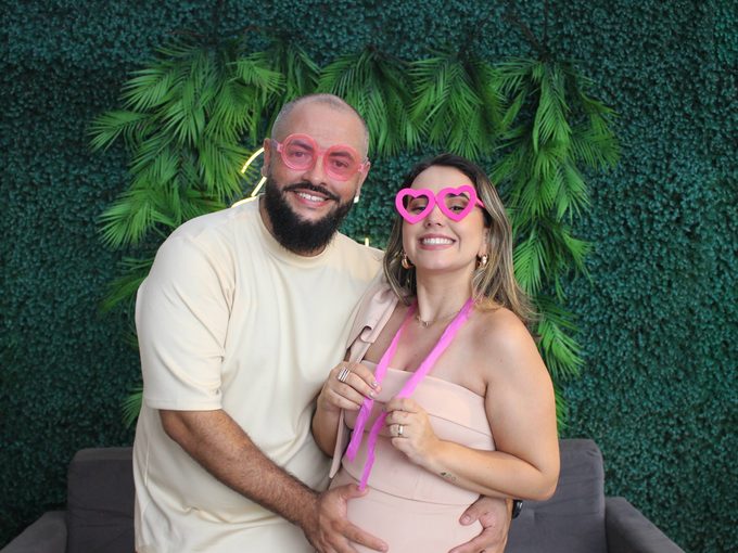 Convidados rindo com óculos de coração na cabine fotográfica