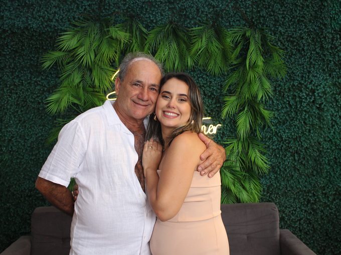 Pai e filha posando juntos na cabine fotográfica