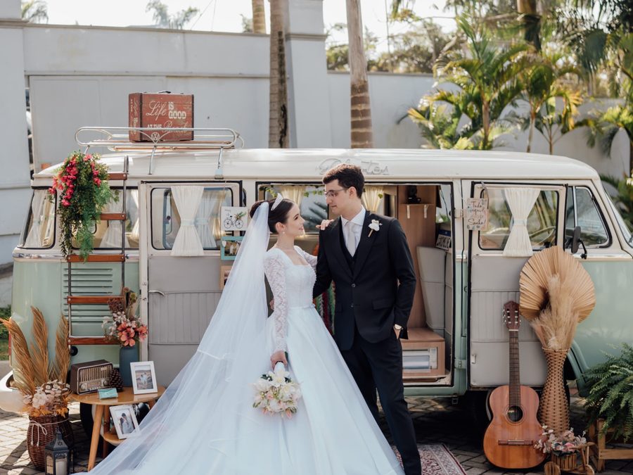 Noivos posando ao lado da Kombi retrô da La Kombine em um casamento ao ar livre